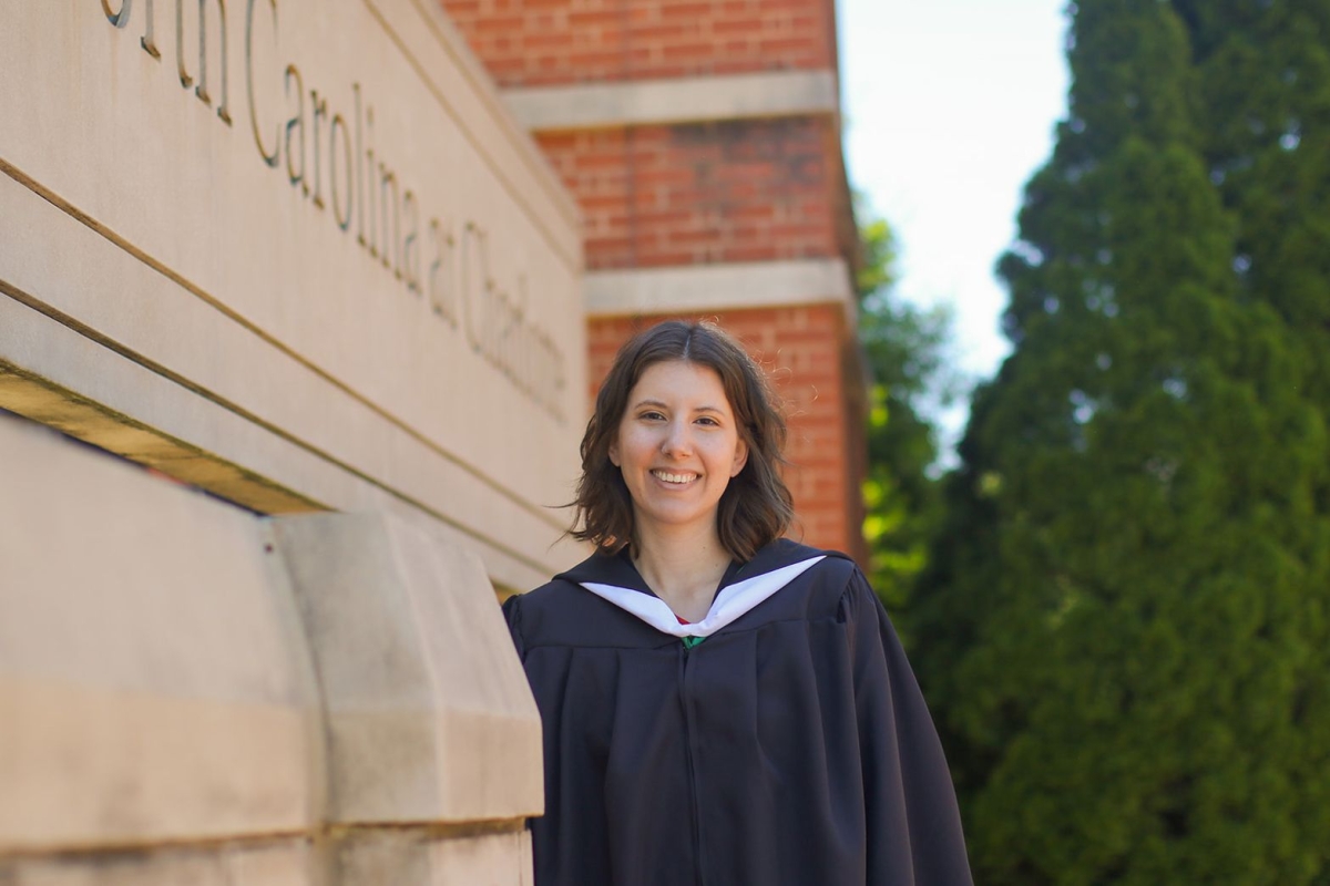 Alyssa Martin during master's graduation in regalia on the UNC Charlotte campus smiling