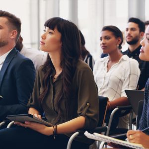 Business people, audience and workshop training or conference meeting in marketing or sales at the office. Group of employee workers or team in seminar for business strategy or coaching at workplace.