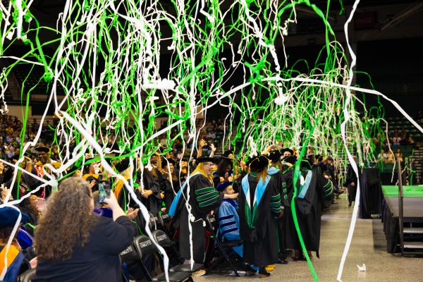 Celebratory confetti goes off as commencement concludes, doctoral graduates celebrating
